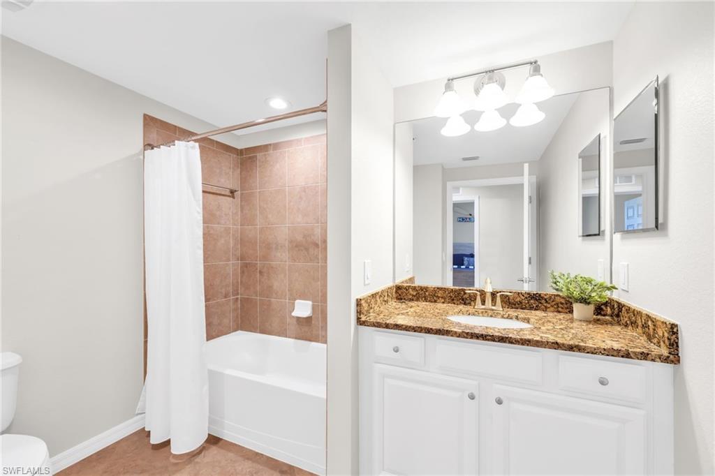 3159 Serena Lane, Unit 102 Naples, FL 34114 - Photo 30 of 42 a bathroom with a granite countertop sink and a mirror