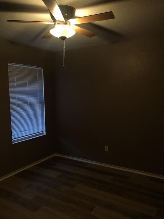 211 Woodley Road Leander, TX 78641 - Photo 10 of 15 A quiet bedroom features warm wood floors and a tall window.