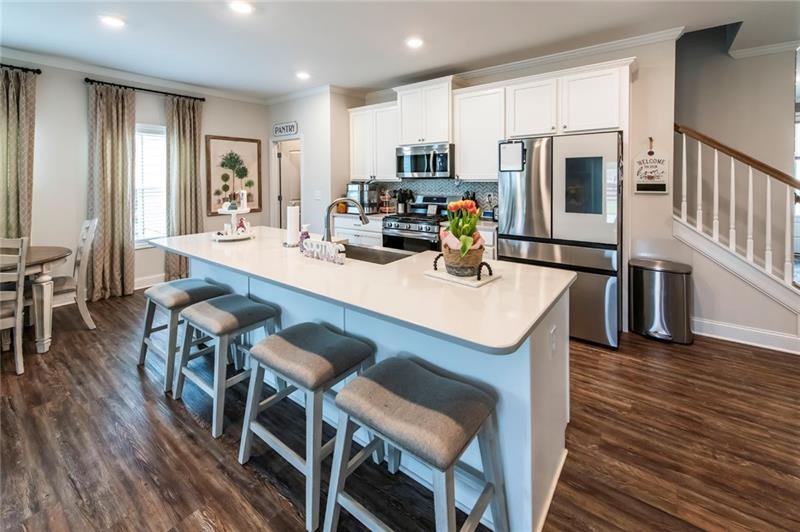 98 Heritage Pointe Drive Villa Rica, GA 30180 - Photo 21 of 48 a kitchen with stainless steel appliances a dining table chairs microwave and refrigerator