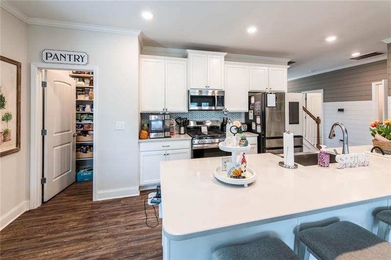98 Heritage Pointe Drive Villa Rica, GA 30180 - Photo 22 of 48 a kitchen with a refrigerator a stove and a sink with wooden floor