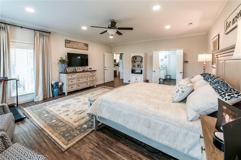 98 Heritage Pointe Drive Villa Rica, GA 30180 - Photo 28 of 48 a bedroom with a large bed a flat tv screen and a dresser