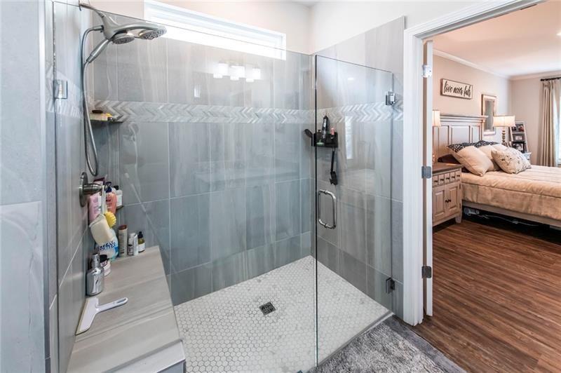 98 Heritage Pointe Drive Villa Rica, GA 30180 - Photo 31 of 48 a bathroom with a tub and a glass door shower