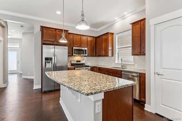 a kitchen with a center island and stainless steel appliances