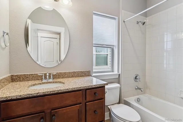 a bathroom with a granite countertop sink toilet and shower