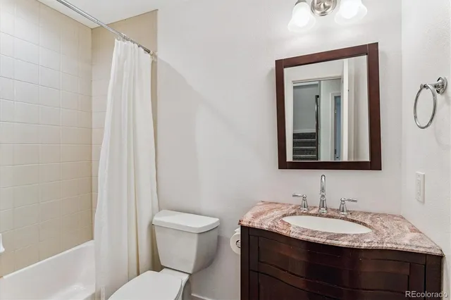 a bathroom with a granite countertop sink toilet and shower