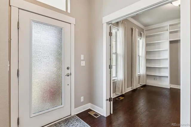 a view of a hallway with wooden floor and closet
