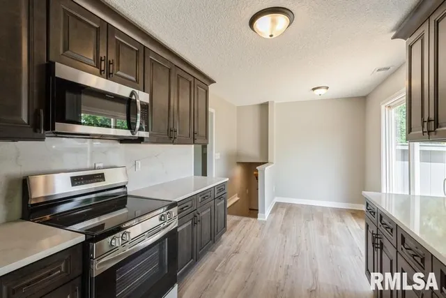 a kitchen with wooden floor and a stove top oven