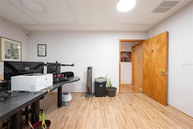 a view of a workspace with furniture and wooden floor