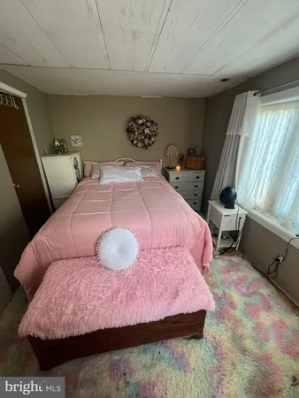 a bedroom with a bed and a large window