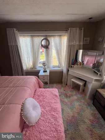 a bedroom with a bed and large windows