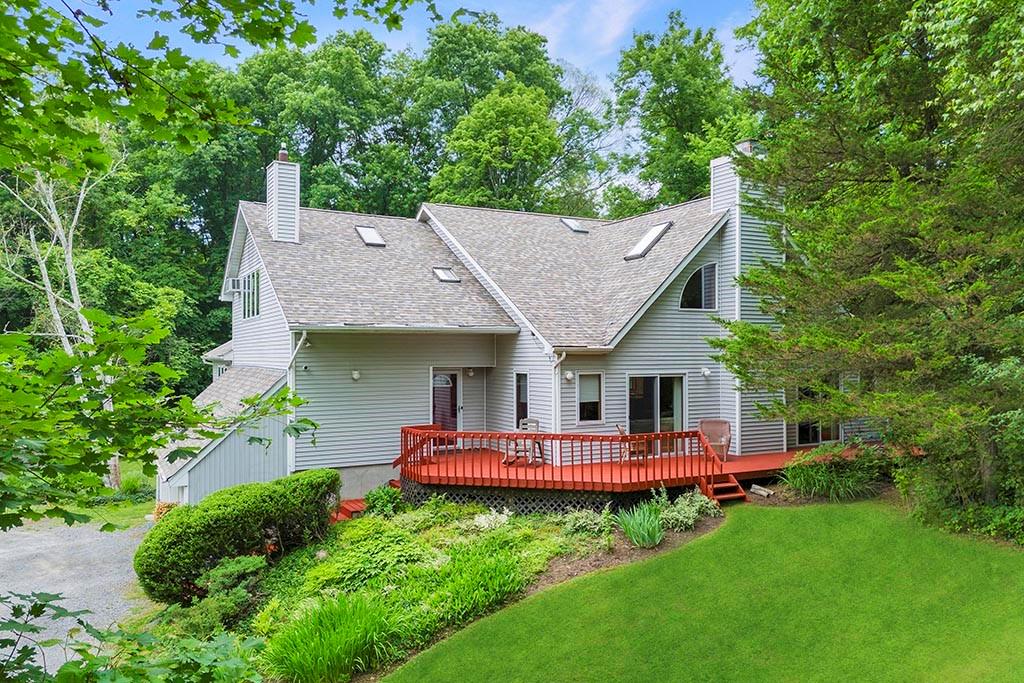 an aerial view of a house with swimming pool and large trees