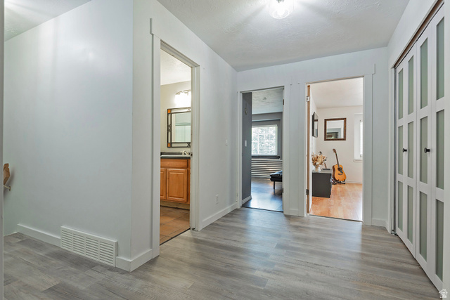 3310 Creek Road Salt Lake City, UT 84121 - Photo 29 of 49 Contemporary hallway with wood-finish flooring, white trim, and a ceiling light fixture