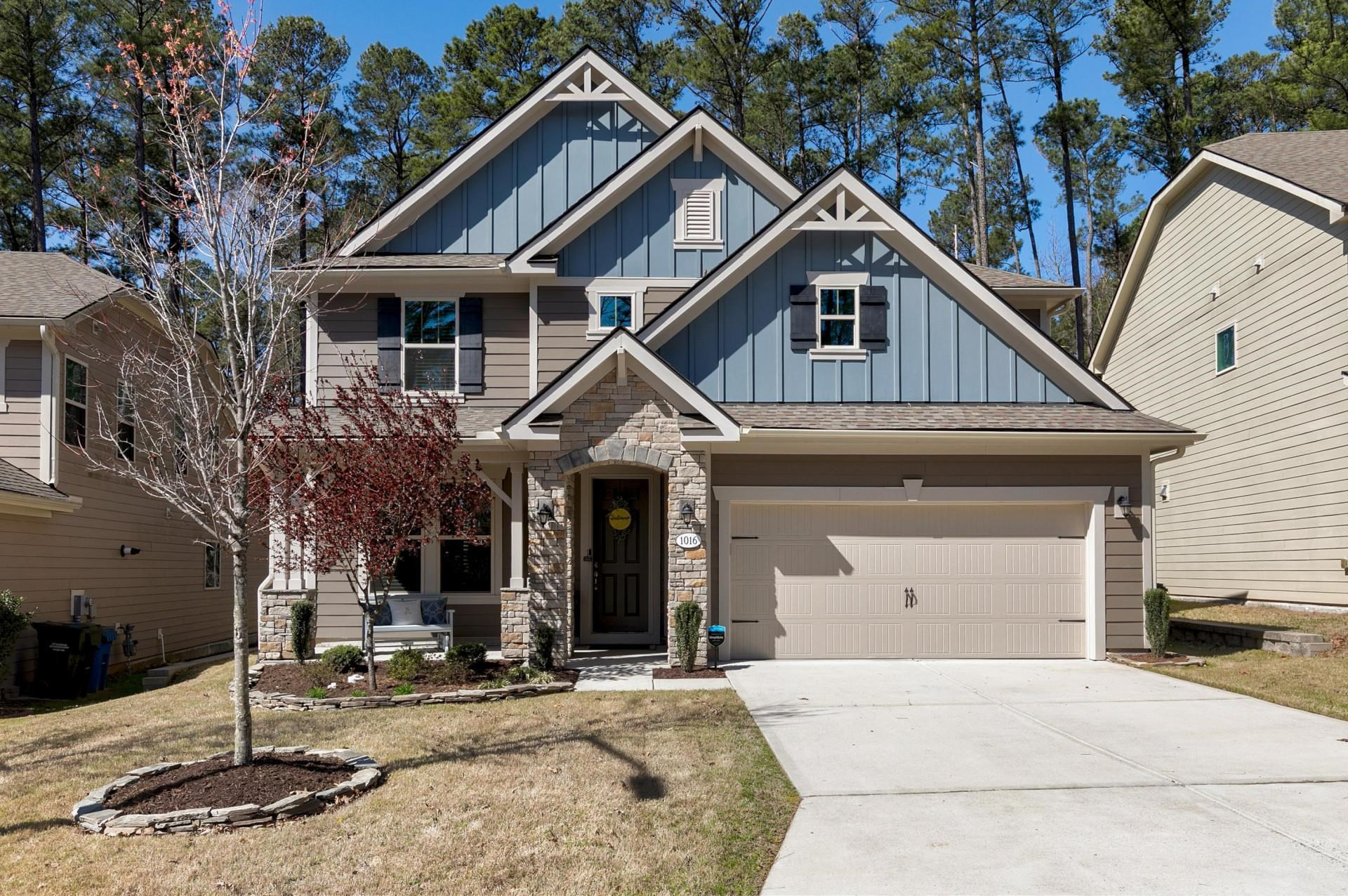 a front view of a house with garden and trees