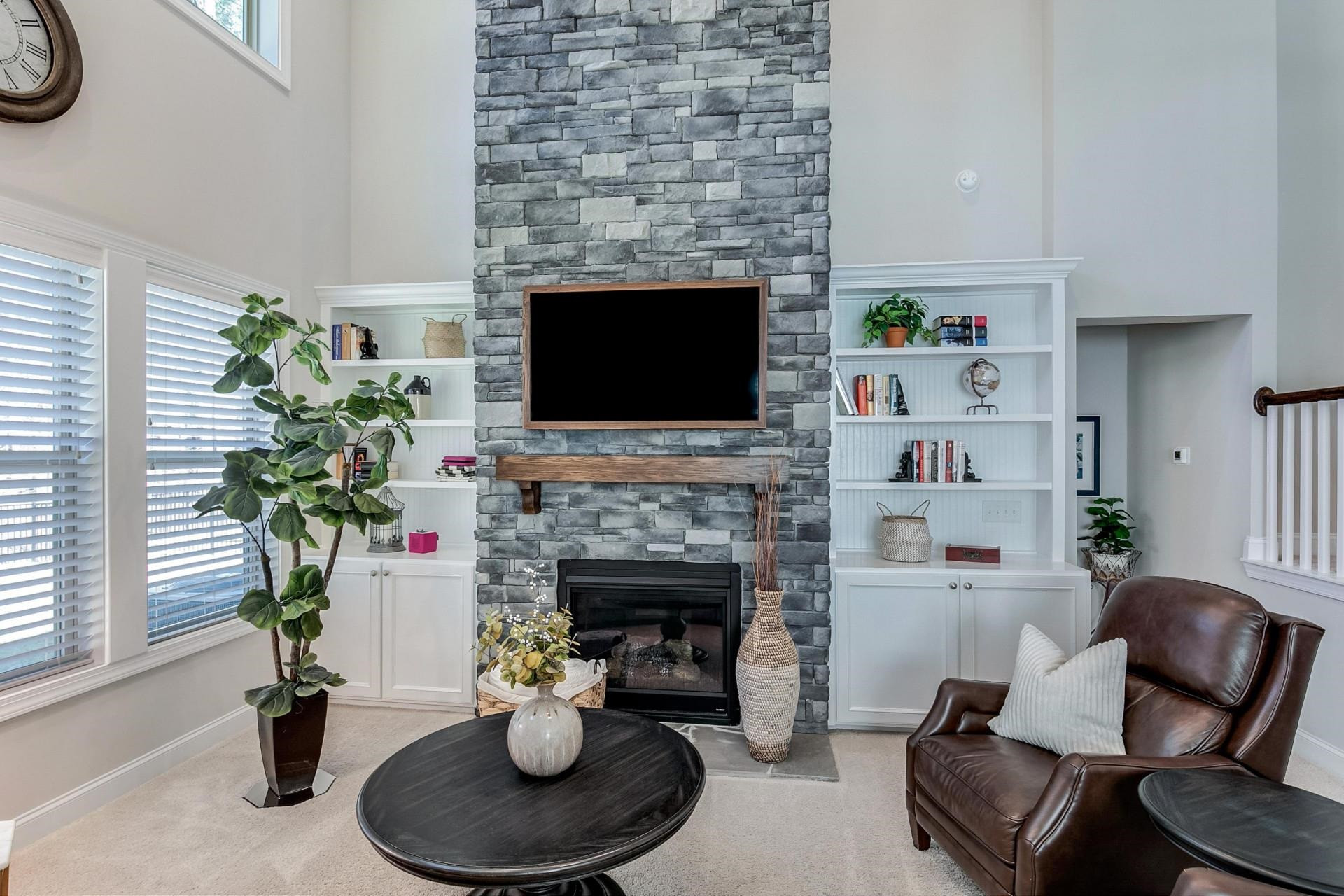 1016 Capstone Drive Durham, NC 27713 - Photo 16 of 50 a living room with furniture a fireplace and a potted plant