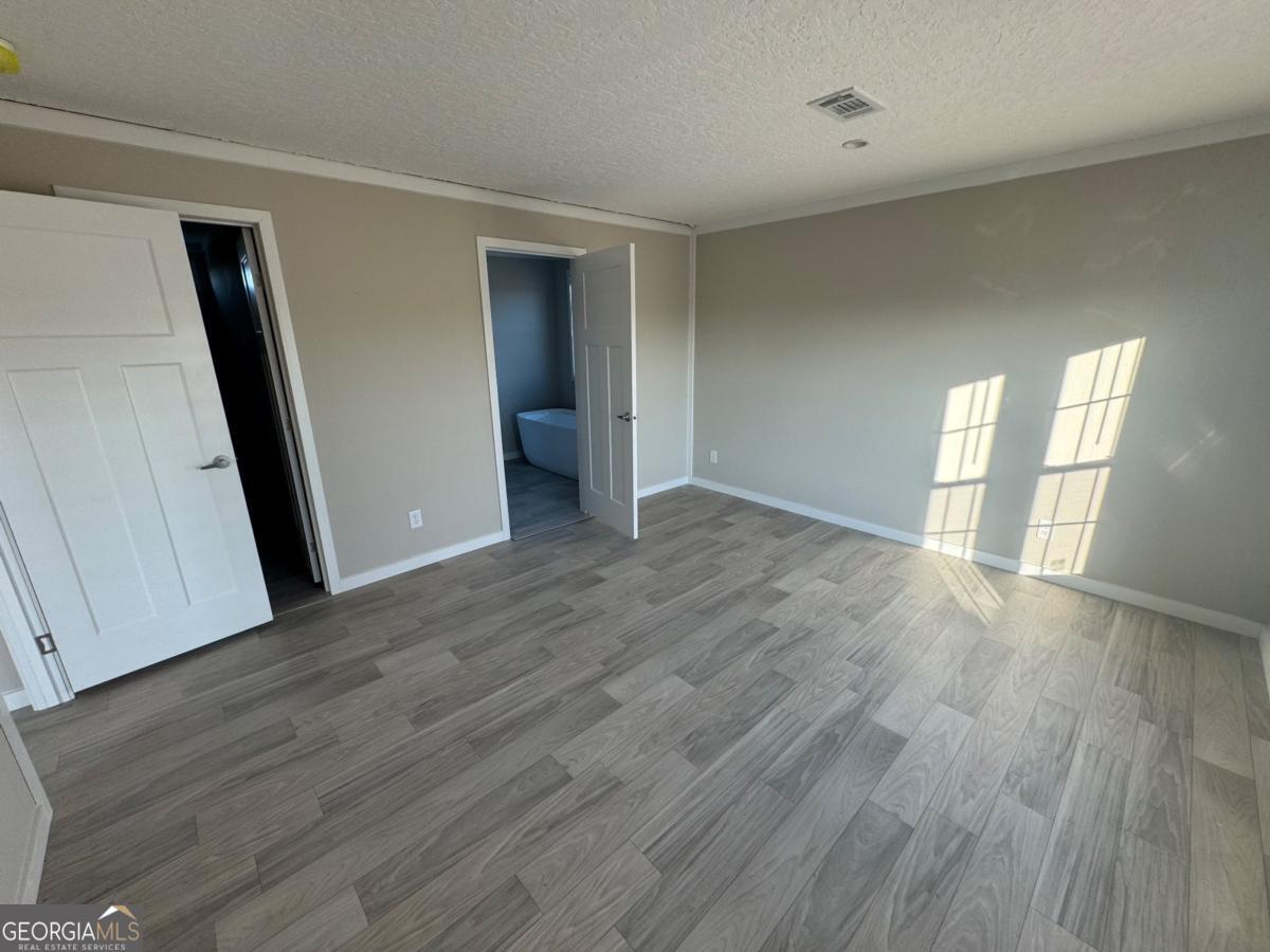 70 Long Leaf Road Hazlehurst, GA 31539 - Photo 15 of 17 wooden floor in an empty room with a window