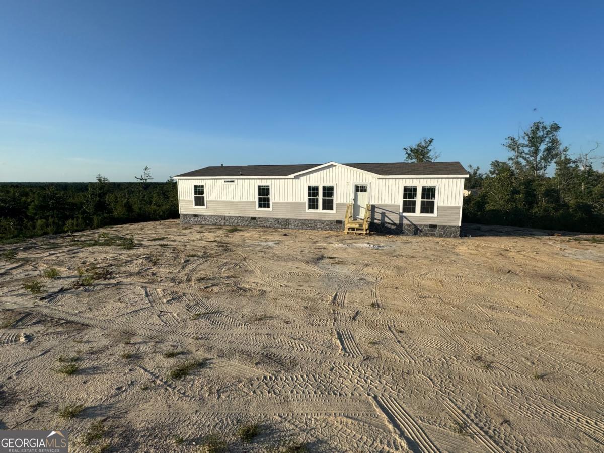 70 Long Leaf Road Hazlehurst, GA 31539 - Photo 2 of 17 a view of house with yard and trees in the background