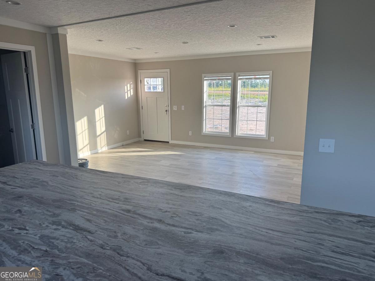 70 Long Leaf Road Hazlehurst, GA 31539 - Photo 6 of 17 a view of an empty room with wooden floor and a window