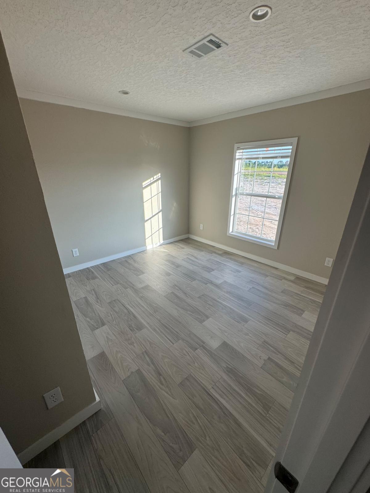 70 Long Leaf Road Hazlehurst, GA 31539 - Photo 10 of 17 a view of an empty room with wooden floor and a window