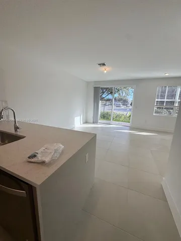 a view of a kitchen with granite countertop sink and cabinets