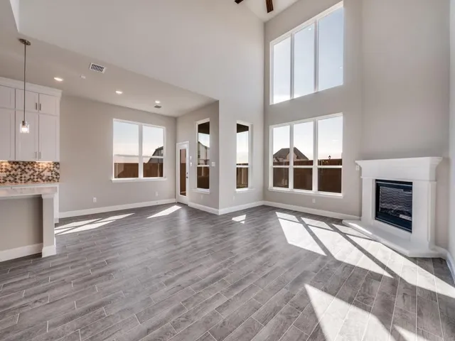 a view of empty room with wooden floor and fireplace