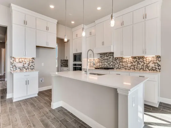 a kitchen with stainless steel appliances granite countertop a sink a stove and a refrigerator