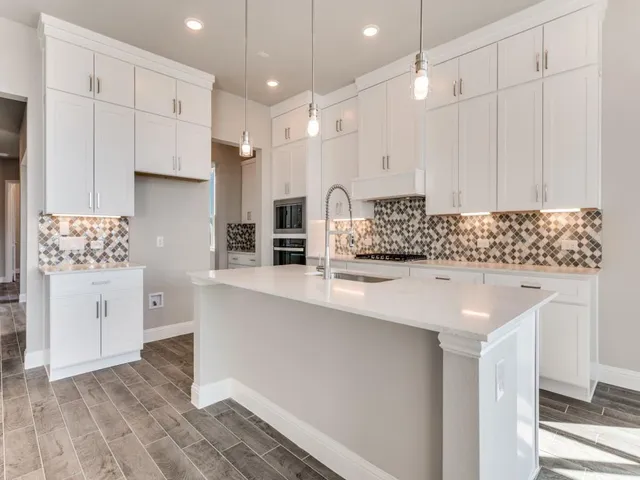 a kitchen with stainless steel appliances granite countertop a sink a stove and a refrigerator