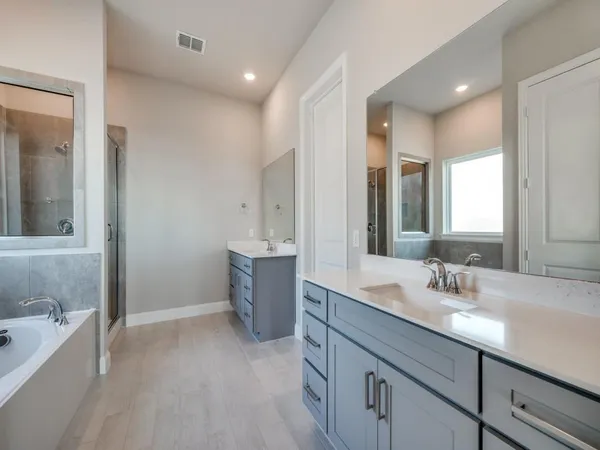 a bathroom with a tub sink and mirror