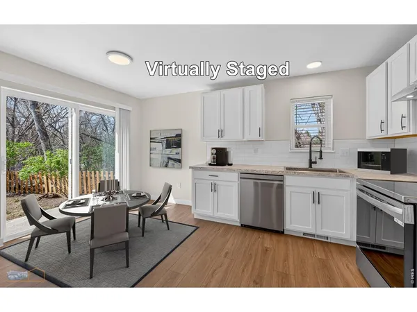 a kitchen with white cabinets a sink dishwasher and white appliances with wooden floor