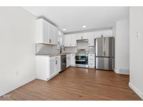 a kitchen with wooden floors and stainless steel appliances