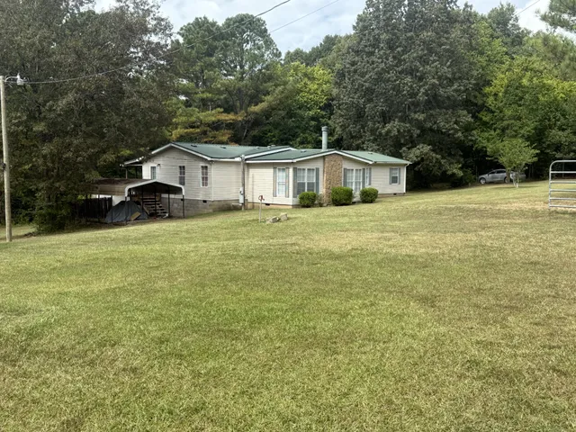 a front view of a house with yard and green space