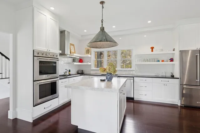 a kitchen with stainless steel appliances a sink stove and cabinets