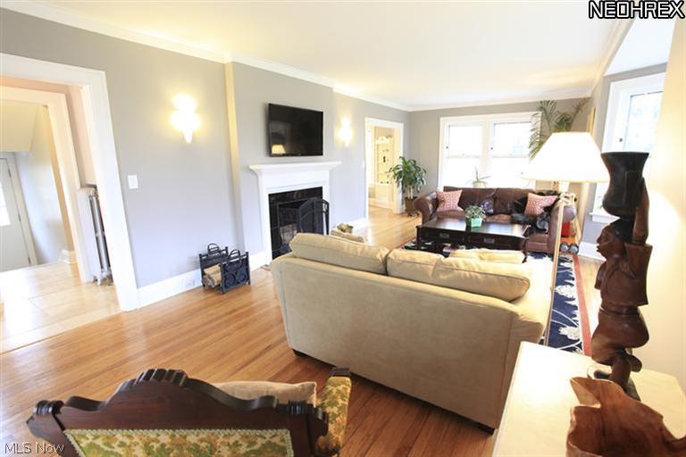 15803 Fernway Road Cleveland, OH 44120 - Photo 25 of 25 This Formal Living Room offers homeowners a wood-burning fireplace, refinished hardwood flooring, bay windows, and wiring for a flat screen to the basement (flatscreen excluded). Sconces flanking the fireplace give warmth to this cozy space, the entrance into the circular floor plan of the home.