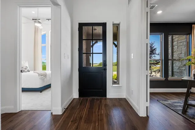 a kitchen with stainless steel appliances a dining table chairs and white cabinets