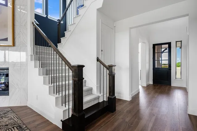 a kitchen with stainless steel appliances granite countertop a sink a stove and a wooden floors