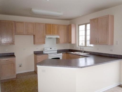 554 Prestwick Lane Wheeling, IL 60090 - Photo 4 of 16 a kitchen with granite countertop a sink stove and cabinets