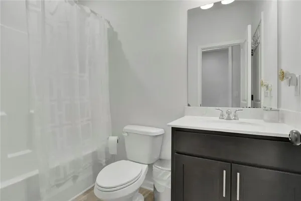 a bathroom with a sink a toilet a mirror and shower