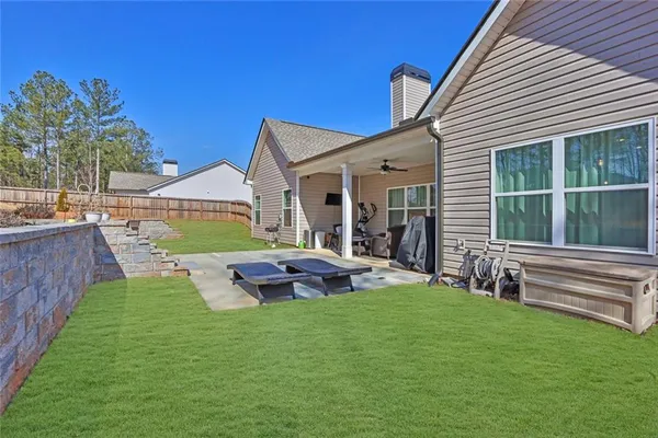 a view of house with backyard and furniture