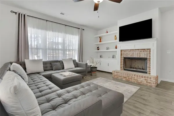 a living room with furniture a fireplace and a flat screen tv
