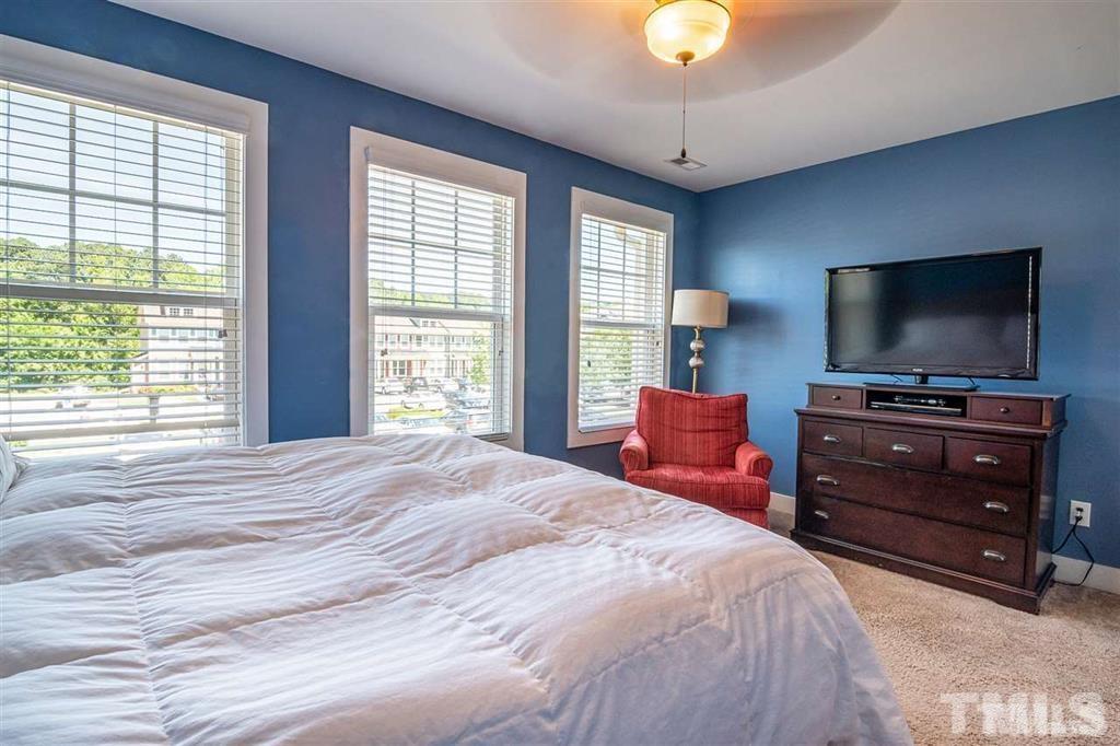 2800 Bedford Green Drive, Unit 106 Raleigh, NC 27604 - Photo 19 of 26 a bedroom with a bed and a flat tv screen on dresser
