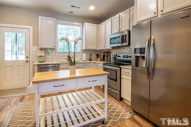 a kitchen with stainless steel appliances a refrigerator sink and microwave