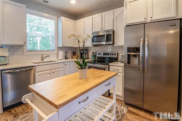 a kitchen with stainless steel appliances a refrigerator sink microwave and cabinets