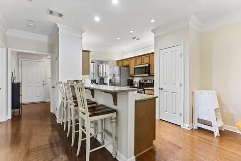 a kitchen with kitchen island granite countertop wooden floors and stainless steel appliances