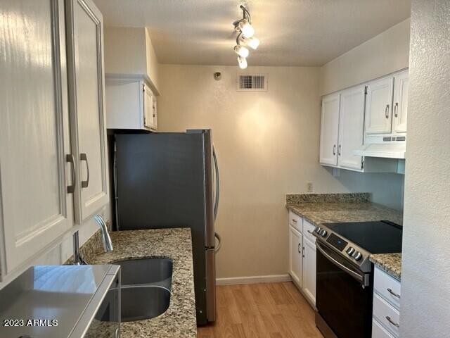 8020 East Thomas Road, Unit 214 Scottsdale, AZ 85251 - Photo 2 of 9 a kitchen with stainless steel appliances granite countertop a refrigerator a stove and a sink with wooden floor
