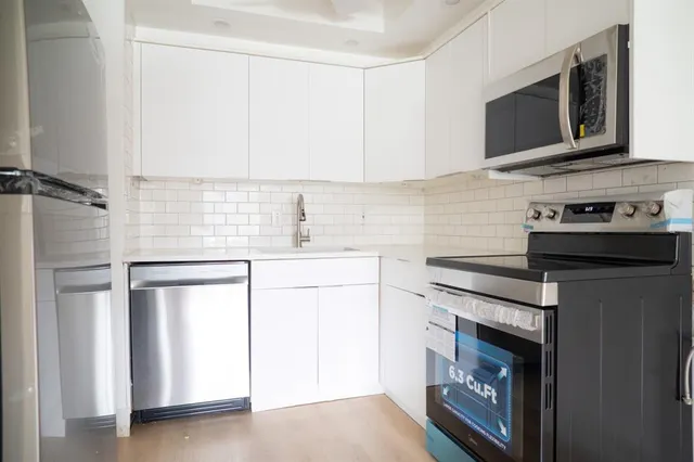 a kitchen with a refrigerator sink and cabinets