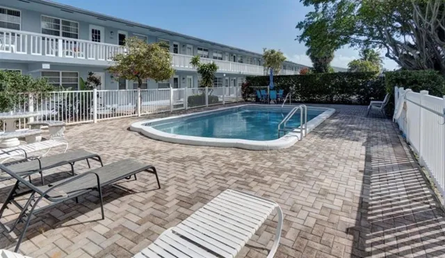 a room with kitchen island a sink a stove and cabinets