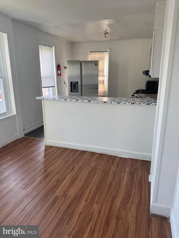 a view of kitchen with wooden floor and electronic appliances