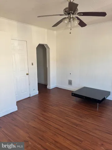 a view of a room with wooden floor and white walls