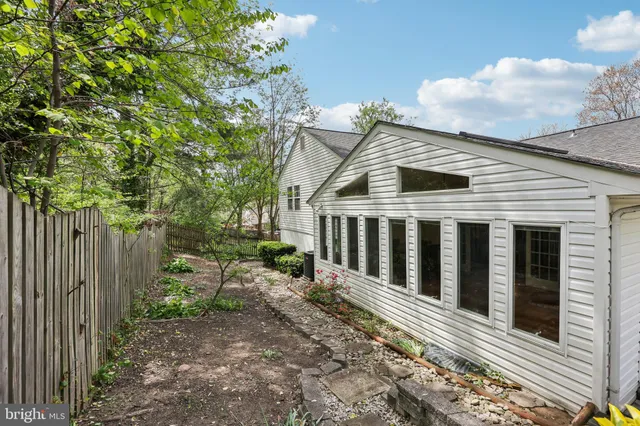 a view of a small house with wooden fence