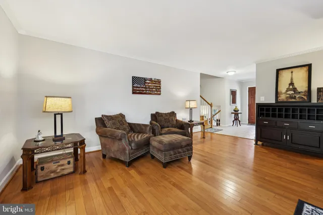 a living room with furniture a lamp and a wooden floor