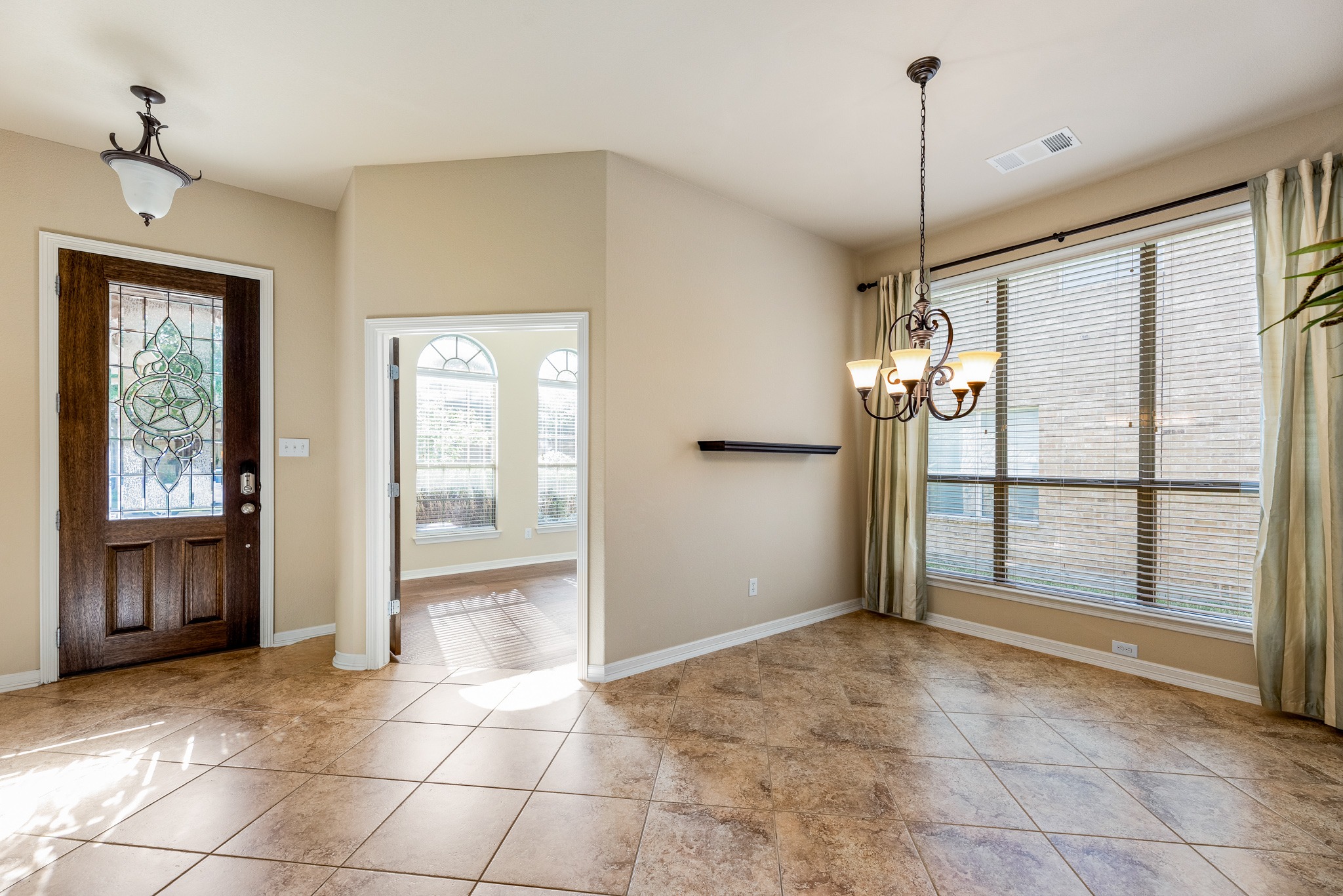 20804 Windmill Ridge Street Pflugerville, TX 78660 - Photo 16 of 40 Formal dining opens off the entry foyer alongside picture windows with a classic chandelier above.
